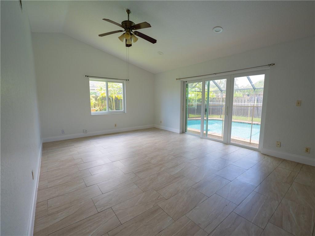 A bright living room features light-colored tile flooring, a vaulted ceiling, and sliding glass doors — 5332 NW 29th Court, Margate FL 33063, MARGATE, FL