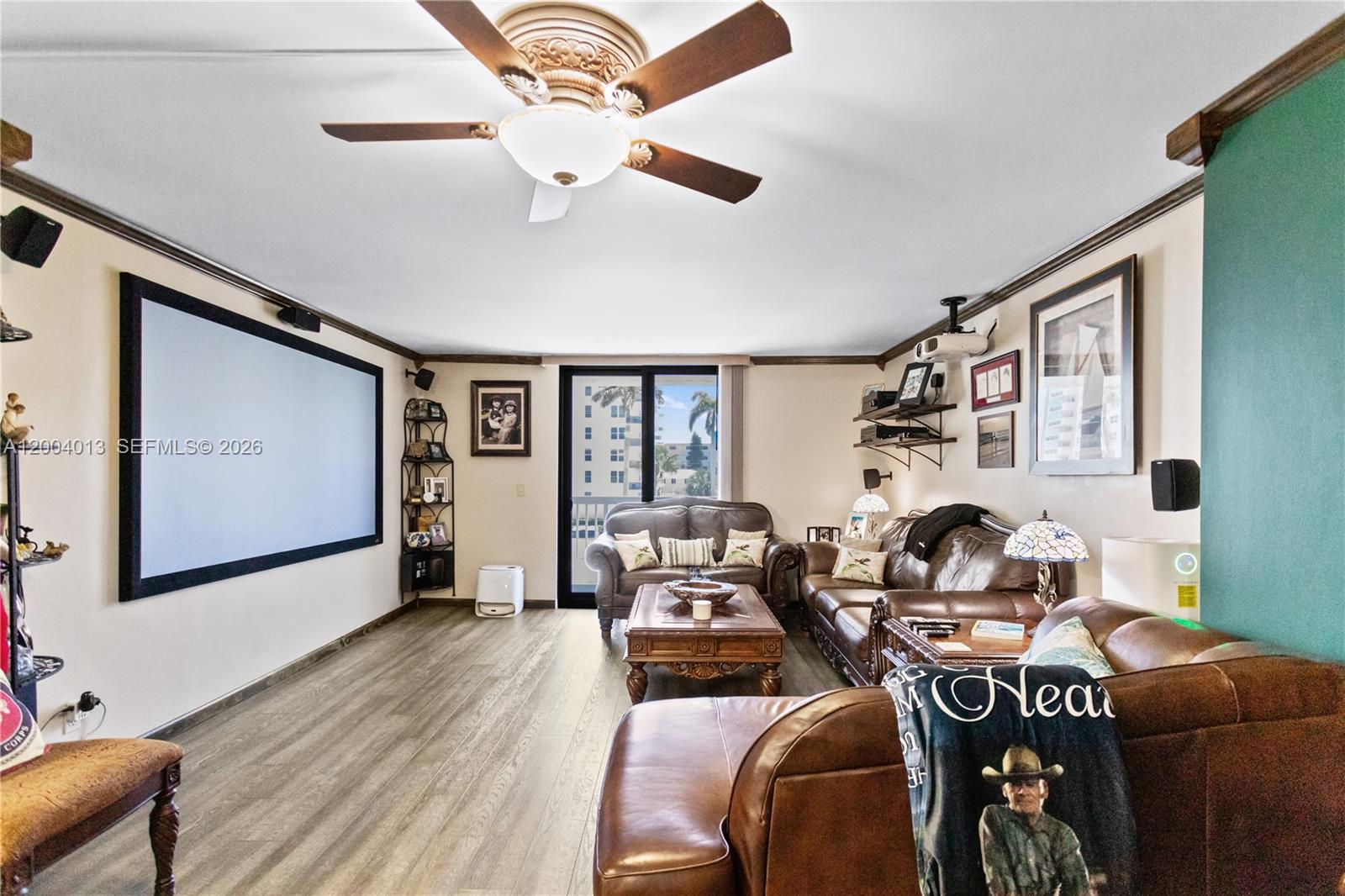 A living room features a large projector screen, leather sofas, and a ceiling fan — 1500 S Ocean Dr # 2G, Hollywood FL 33019, HOLLYWOOD, FL