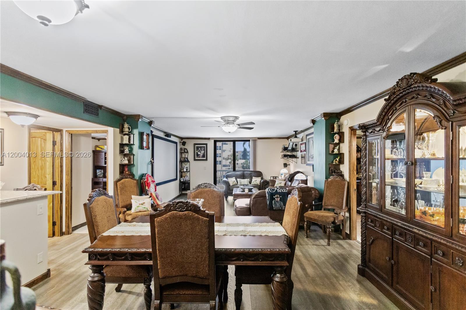 A dining area with a wooden table leads into a living room featuring a projection screen — 1500 S Ocean Dr # 2G, Hollywood FL 33019, HOLLYWOOD, FL