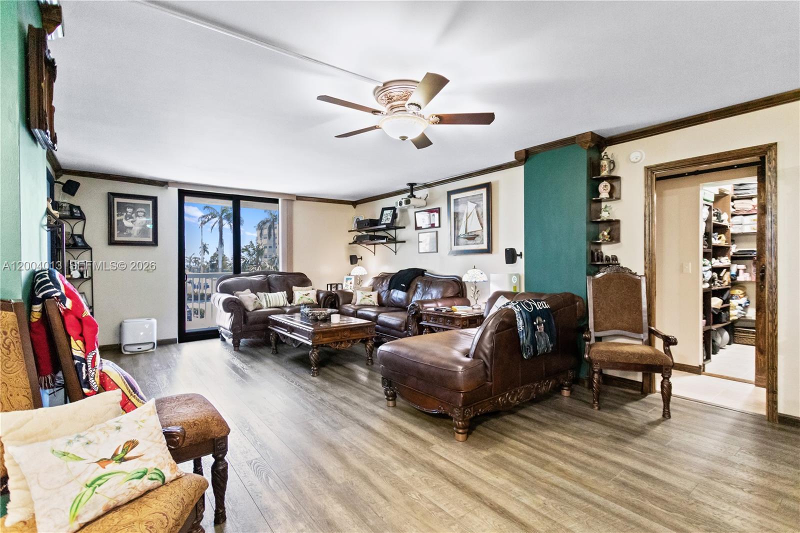 A living room features brown leather furniture, wood-look flooring, and a balcony with palm trees — 1500 S Ocean Dr # 2G, Hollywood FL 33019, HOLLYWOOD, FL