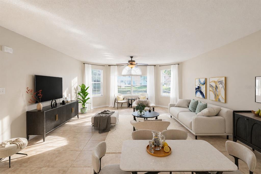 A bright living room features tile floors, a ceiling fan, and a neutral color palette — 2731 N POINCIANA BOULEVARD UNIT 107, KISSIMMEE, FL