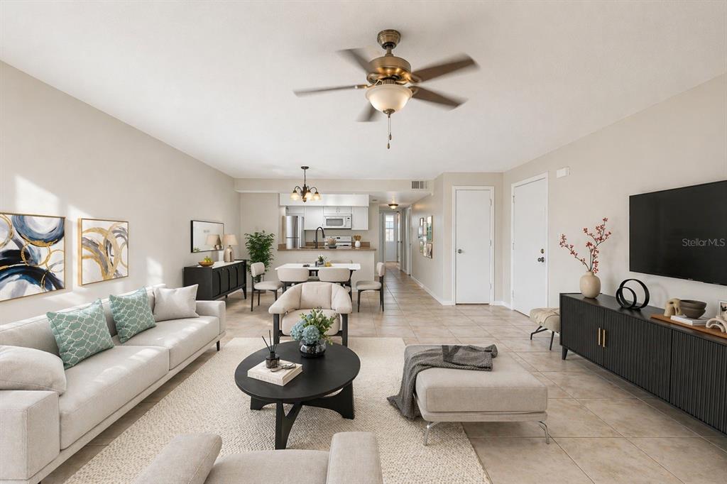 A bright living room features a beige sofa, round coffee table, and an open kitchen — 2731 N POINCIANA BOULEVARD UNIT 107, KISSIMMEE, FL