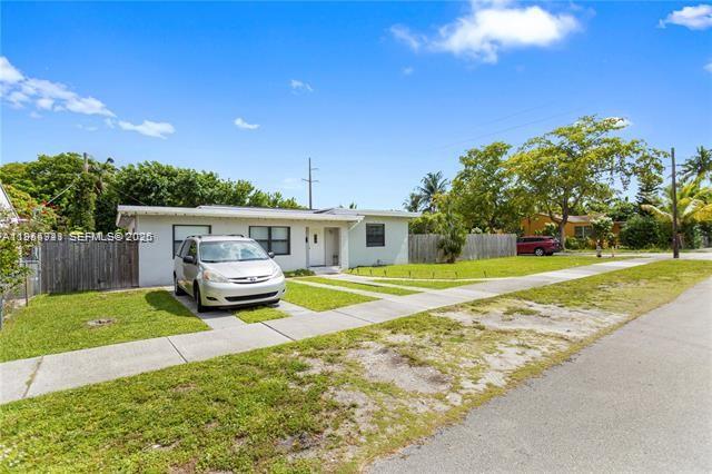 A single-story house with a light-colored exterior and a silver minivan parked in front — 2407 Dewey St, Hollywood FL 33020, HOLLYWOOD, FL