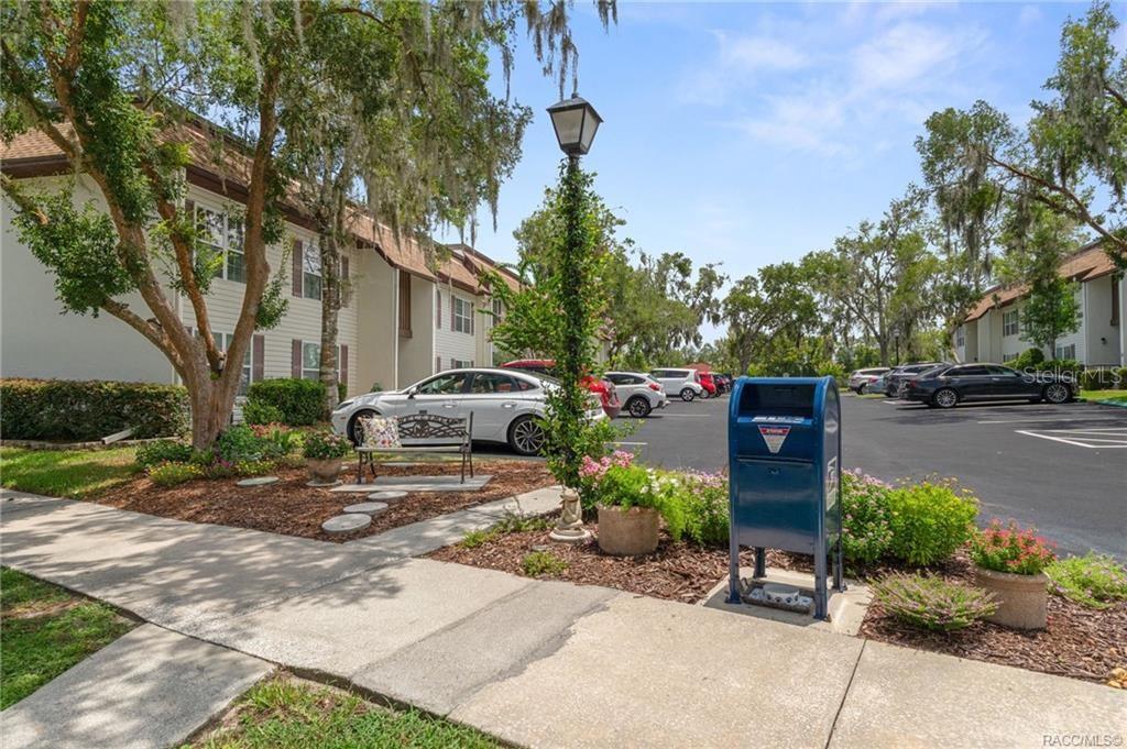 An outdoor parking lot with a blue mailbox, a lamppost, and apartment buildings — 2400 FOREST DRIVE UNIT 221, INVERNESS, FL