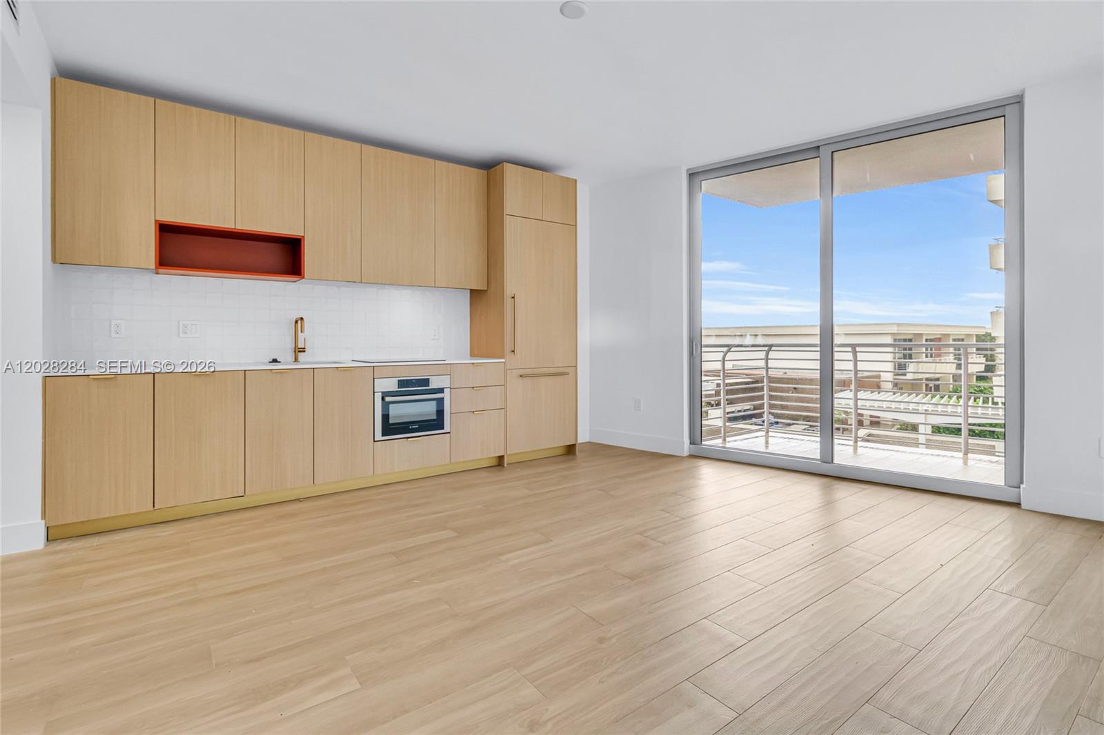 A modern kitchen with light wood cabinetry and a balcony view is in this room — 90 NE 32 # 714, Miami FL 33127, MIAMI, FL