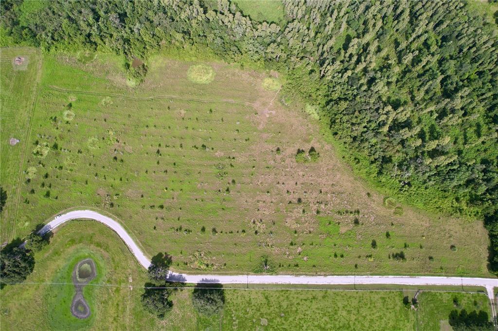 An aerial view shows a large, grassy, partially wooded lot bordered by a curved road — 0 HANCOCK ROAD, LAKELAND, FL