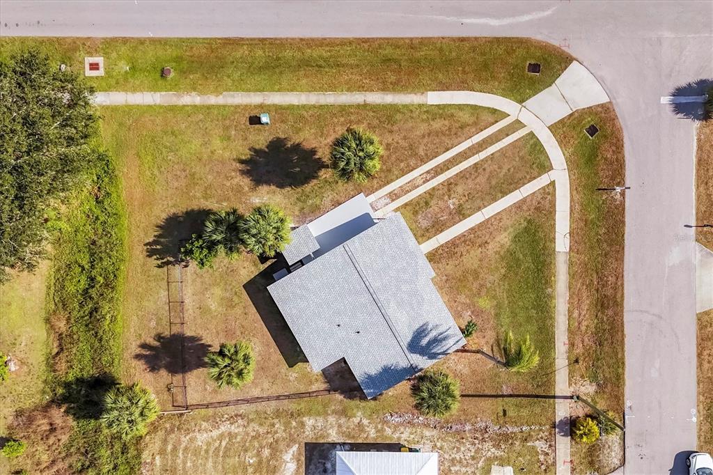 An aerial view shows a house on a corner lot with a driveway and landscaping — 22152 LARAMORE AVENUE, PORT CHARLOTTE, FL
