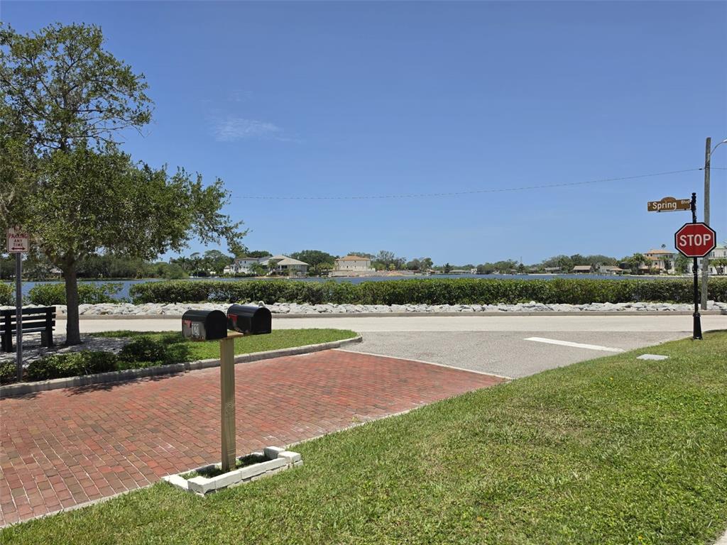 A brick driveway leads to a street with a stop sign overlooking a waterfront view — 121 BAY STREET, TARPON SPRINGS, FL