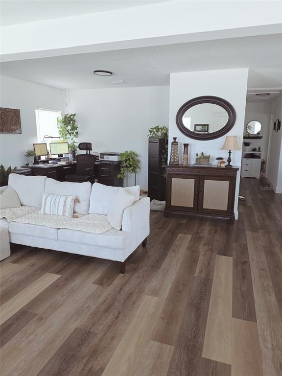 A living room features a white sofa, a dark wood cabinet, and a home office area — 121 BAY STREET, TARPON SPRINGS, FL