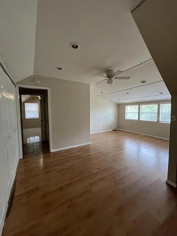 A room with wood-look flooring, a ceiling fan, recessed lighting, and a doorway to another room — 875 S LAKE SHORE WAY, LAKE ALFRED, FL