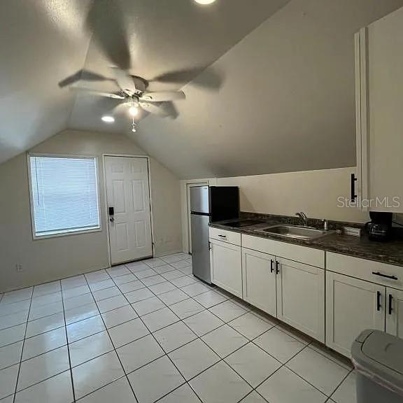 A kitchen with white cabinets, tile flooring, and a slanted ceiling under a ceiling fan — 875 S LAKE SHORE WAY, LAKE ALFRED, FL