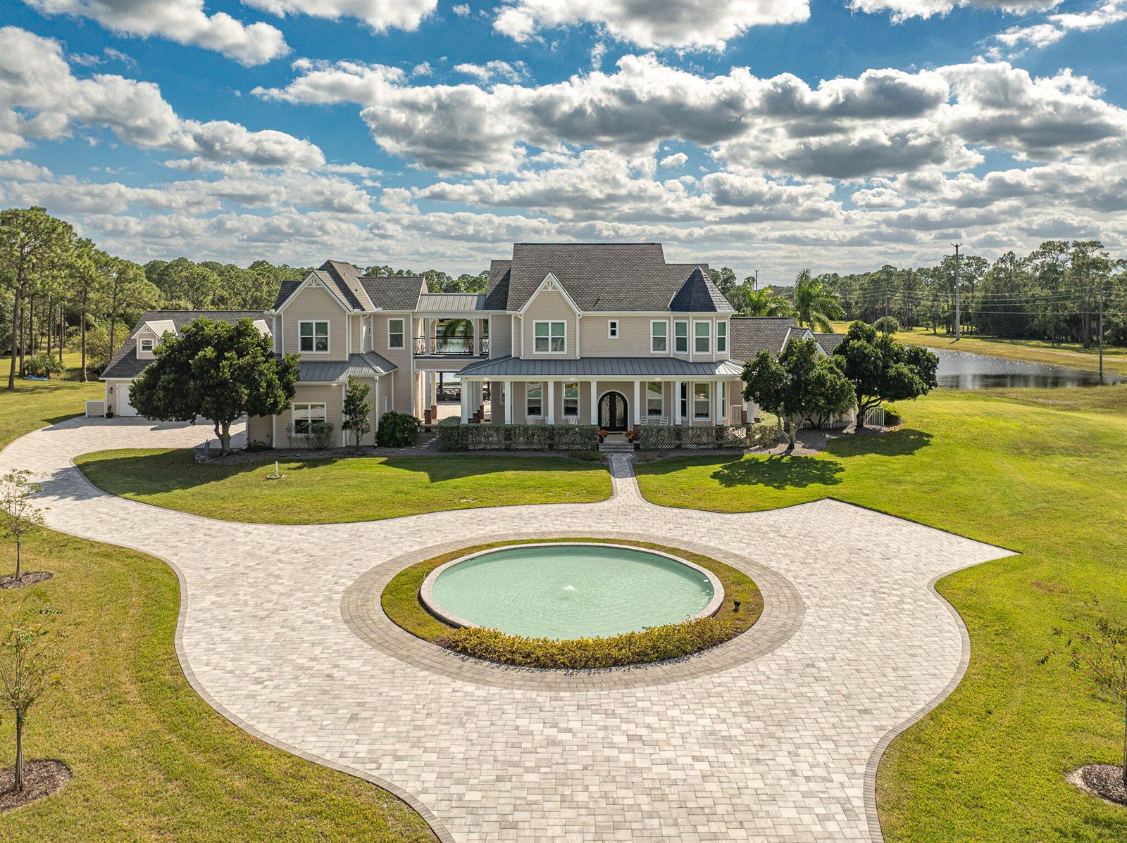 An aerial view shows a large house with a circular fountain in the paved driveway — 4236 Hield Road NW, Palm Bay FL 32907, PALM BAY, FL