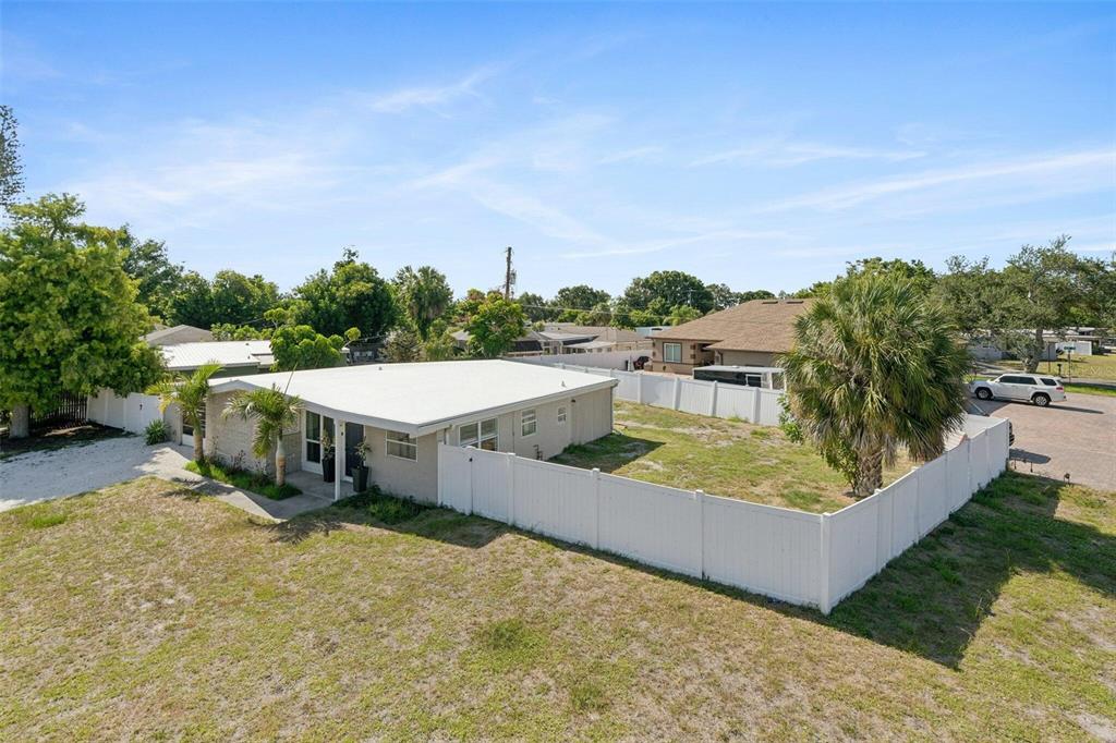 An aerial view shows a single-story house with a white roof and a fenced yard — 2416 EMORY AVENUE, BRADENTON, FL