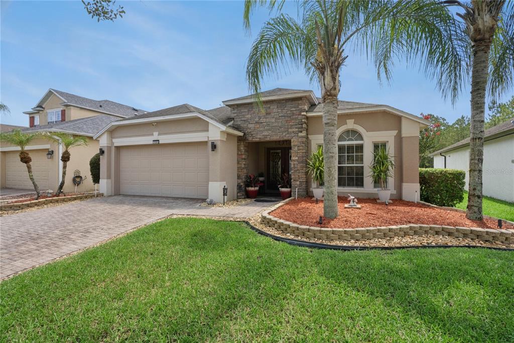 A single-story house with a stone facade, a two-car garage, and a landscaped front yard — 1519 BALSAM WILLOW TRAIL, ORLANDO, FL