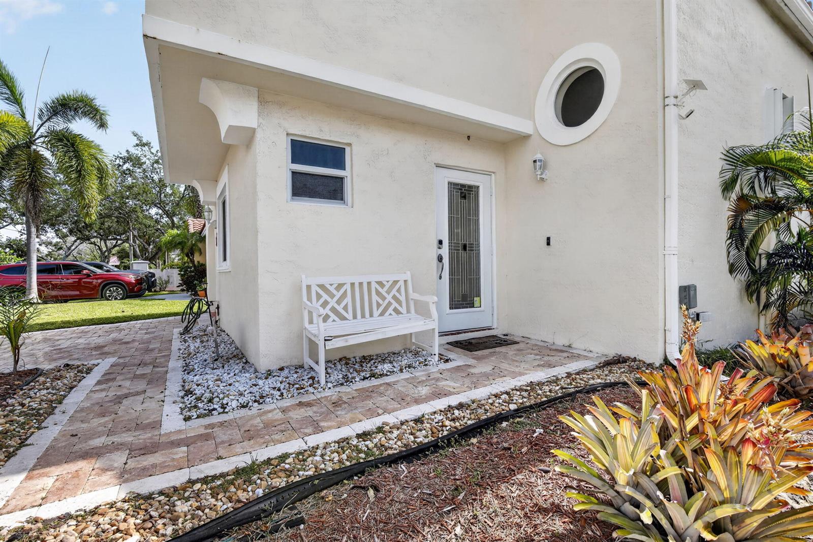 A white exterior wall features a door, a small window, a circular window, and a bench — 1306 SE 5th Court, Dania Beach FL 33004, DANIA BEACH, FL