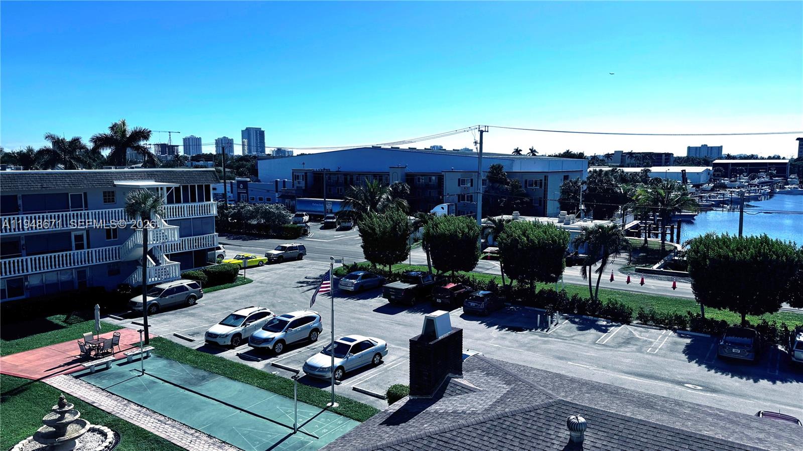 An elevated view shows a parking lot, a residential building, and a nearby marina — 1965 SE 5th Ct # 203, Pompano Beach FL 33060, POMPANO BEACH, FL