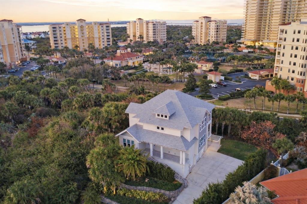 An aerial view of a multi-story house surrounded by trees near a large resort complex — 2142 VILLA WAY, NEW SMYRNA BEACH, FL