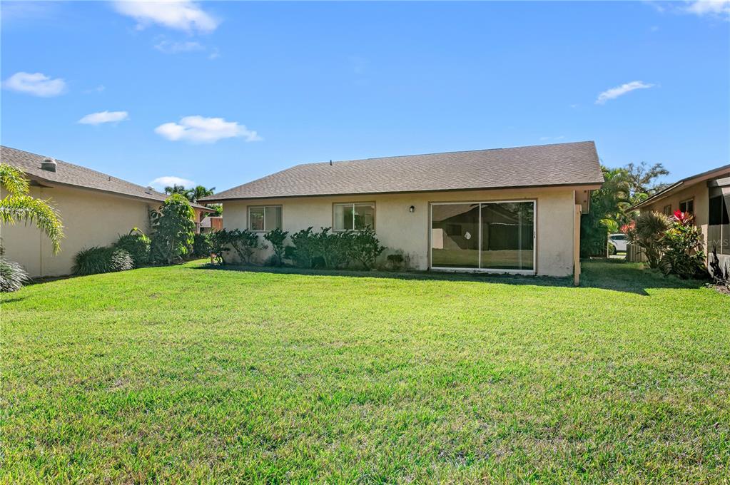 The exterior view shows the back of a single-story house with a large grassy yard — 6479 ROYAL WOODS DRIVE, FORT MYERS, FL