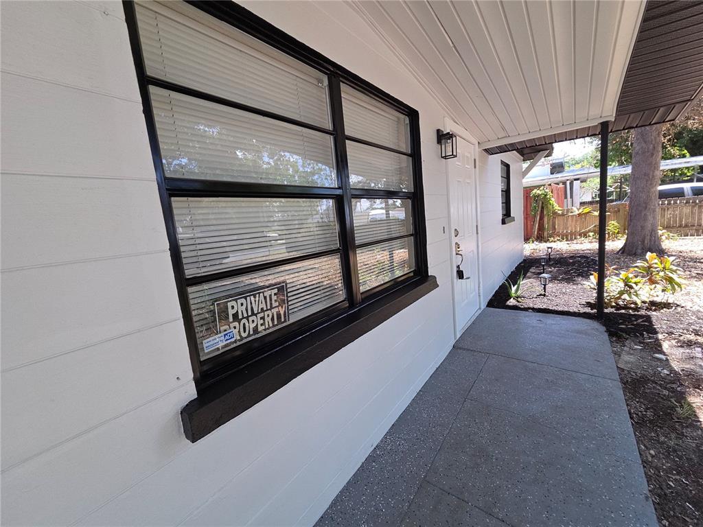 A white house exterior features a black-framed window with a private property sign — 419 32ND AVENUE E, BRADENTON, FL