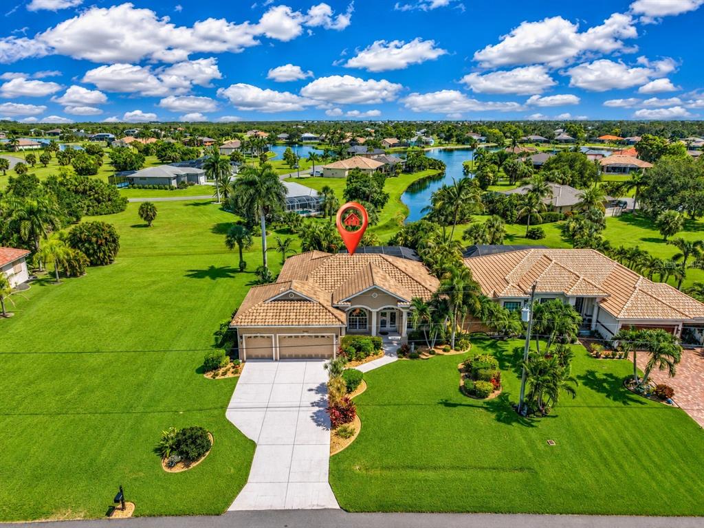 An aerial view of a single-story house with a tile roof and a concrete driveway — 24228 PEPPERCORN ROAD, PUNTA GORDA, FL