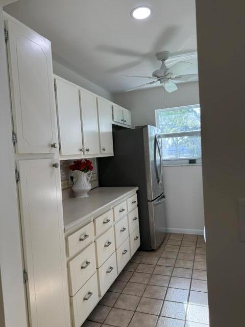 A kitchen features white cabinets, a stainless steel refrigerator, and light-colored tile flooring — 7293 W Oakridge Circle, Lake Worth FL 33462, LAKE WORTH, FL