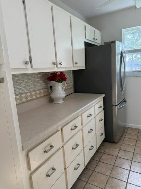 A kitchen features white cabinets, a beige countertop, a tiled backsplash, and a stainless refrigerator — 7293 W Oakridge Circle, Lake Worth FL 33462, LAKE WORTH, FL