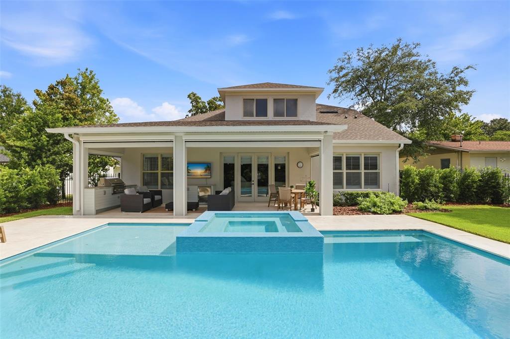 A two-story house with a front porch, stone pillars, and an attached garage — 1750 CAROLLEE LANE, WINTER PARK, FL