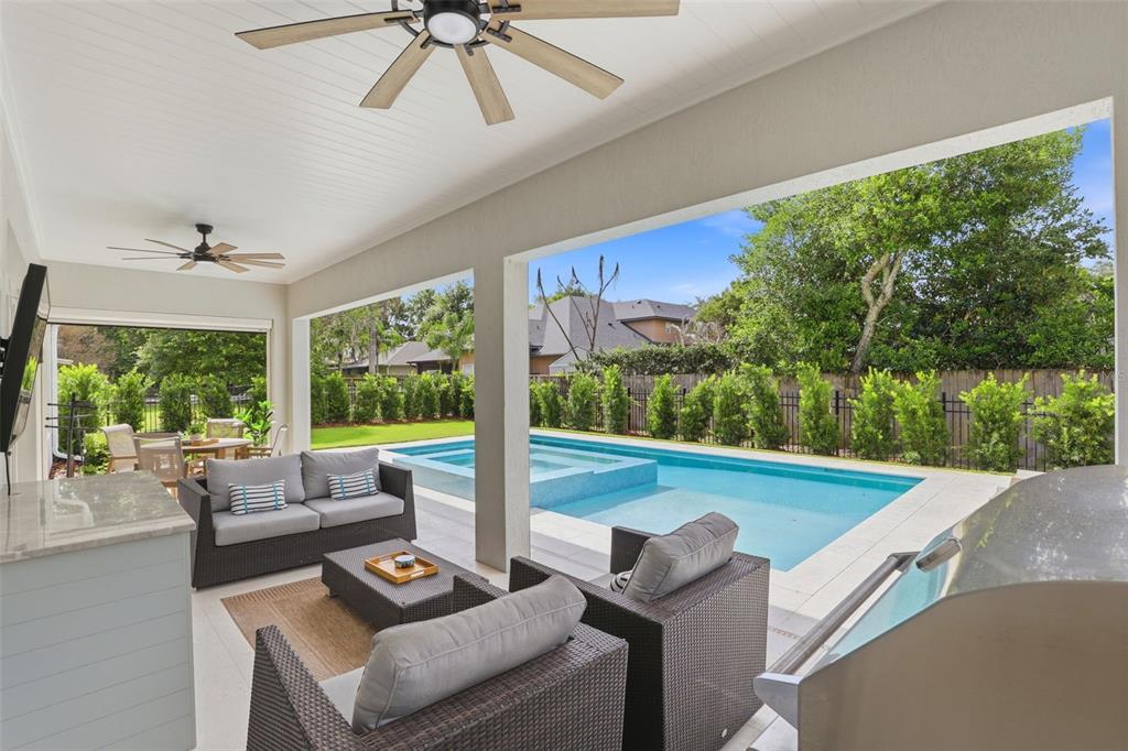 A covered patio overlooks a swimming pool with an integrated spa and a fenced backyard — 1750 CAROLLEE LANE, WINTER PARK, FL