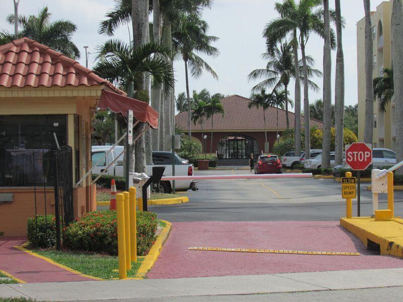 A gated entrance with a security booth, a red-tiled roof, and a stop sign — 7000 NW 186th Street # 316, Hialeah FL 33015, HIALEAH, FL