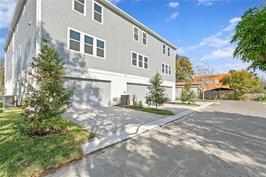A multi-story gray siding townhouse features a row of garages and paved driveways — 208 W FRANCES AVENUE UNIT 3, TAMPA, FL