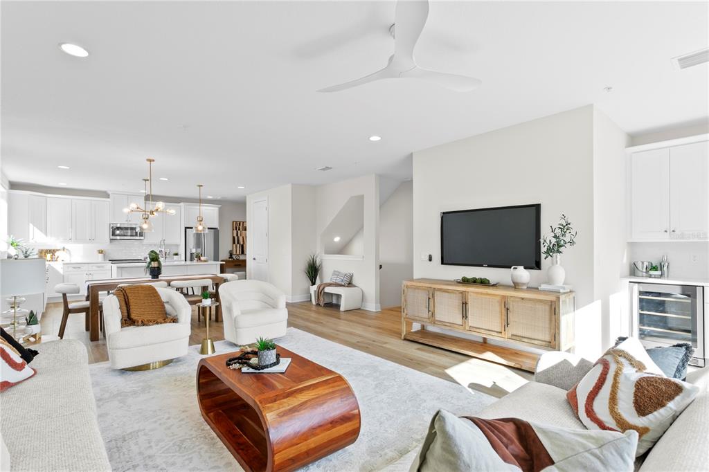 An open-concept living room and kitchen featuring light wood floors, white cabinetry, and modern furniture — 208 W FRANCES AVENUE UNIT 3, TAMPA, FL