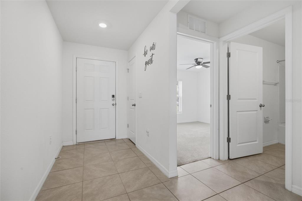 A tiled entryway leads to a bedroom and a bathroom with white doors and walls — 9295 VAN ALLEN WAY, SPRING HILL, FL