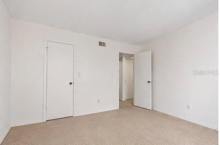 A kitchen features white appliances, dark cabinets, white countertops, and a double-basin sink — 10200 GANDY BOULEVARD N UNIT 714, ST PETERSBURG, FL
