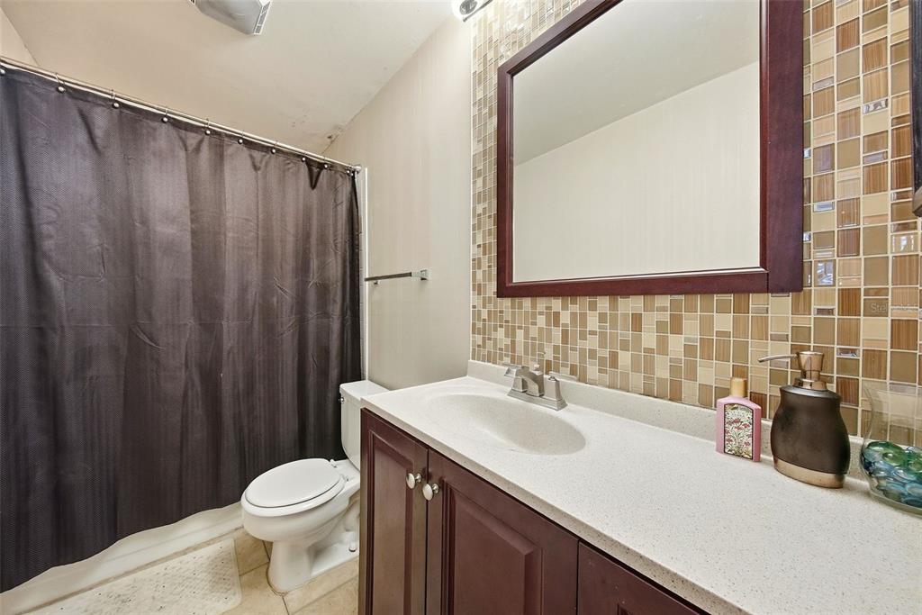 A kitchen features dark cabinets, white appliances, and an adjacent laundry closet with a stacked unit — 10200 GANDY BOULEVARD N UNIT 714, ST PETERSBURG, FL