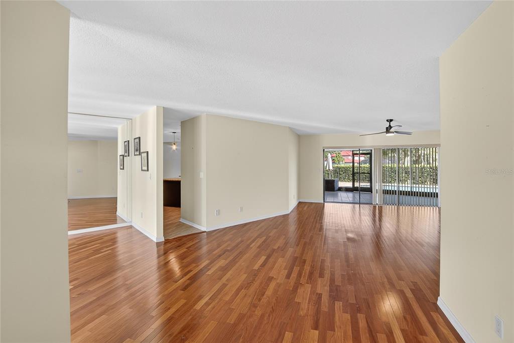 An open living area with hardwood floors, a ceiling fan, and sliding glass patio doors — 2004 N GOLFVIEW DRIVE, PLANT CITY, FL