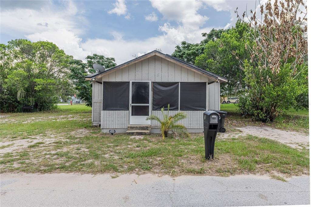 A small, light-colored, single-story house with a screened-in front porch and a black mailbox — 5 NORTH STREET, FROSTPROOF, FL
