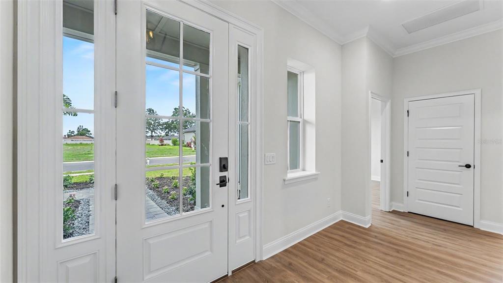 A bright living room features light wood-look flooring, a vaulted ceiling, and a ceiling fan — 5367 CLUBHOUSE HILLS LANE, LAKELAND, FL