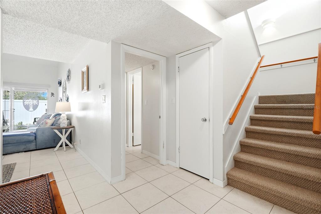 A bright entryway features tiled floors, a carpeted staircase, and a doorway leading to another room — 2062 SUNSET POINT ROAD UNIT 64, CLEARWATER, FL
