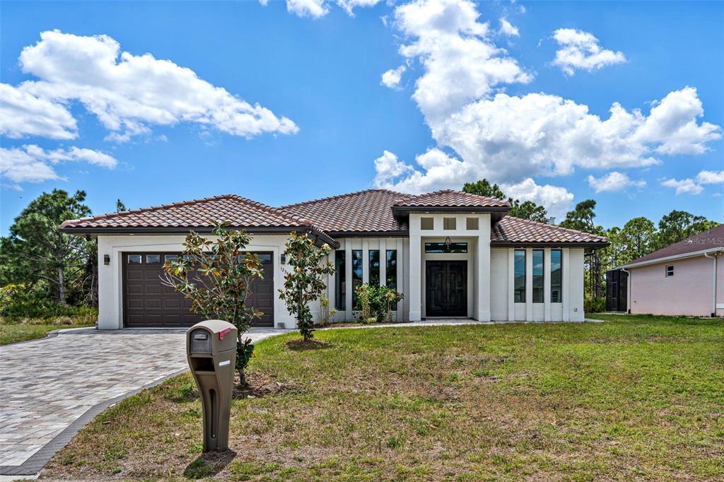 A single-story house with a tiled roof, stucco exterior, and a paved driveway — 12347 DURANGO AVENUE, NORTH PORT, FL