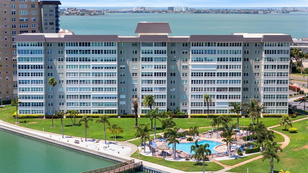An aerial view of a multi-story apartment building with a pool and waterfront dock — 5130 BRITTANY DRIVE S UNIT 505, ST PETERSBURG, FL