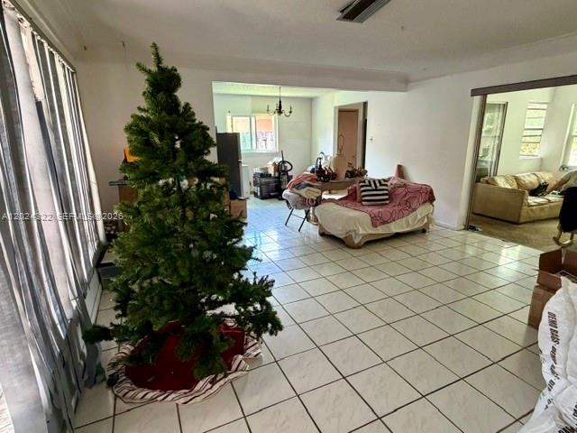 A living room features a large artificial Christmas tree and tiled flooring — 8001 NW 3rd Pl, Margate FL 33063, MARGATE, FL