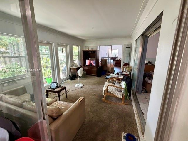 A sunroom with carpeted floors, a sofa, a rocking chair, and sliding glass doors — 8001 NW 3rd Pl, Margate FL 33063, MARGATE, FL