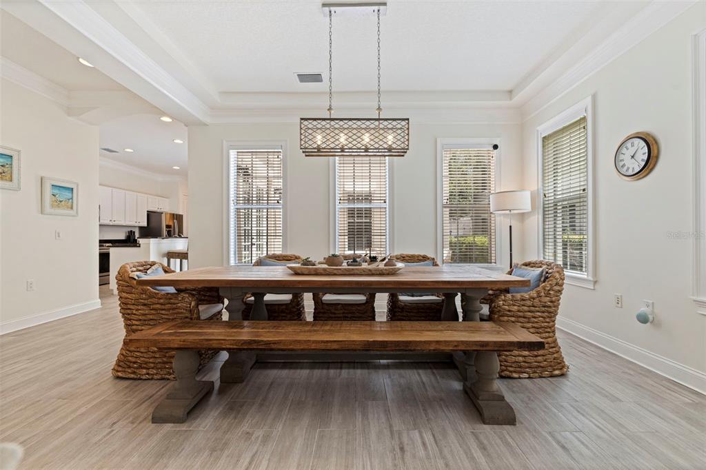 A bedroom features a patterned upholstered bed, a patterned armchair, and three windows — 125 COMMONWEALTH COURT N, ST PETERSBURG, FL