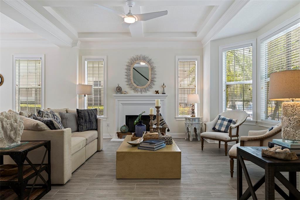 A paved patio features a wooden bench with patterned cushions and a wall-mounted outdoor clock — 125 COMMONWEALTH COURT N, ST PETERSBURG, FL