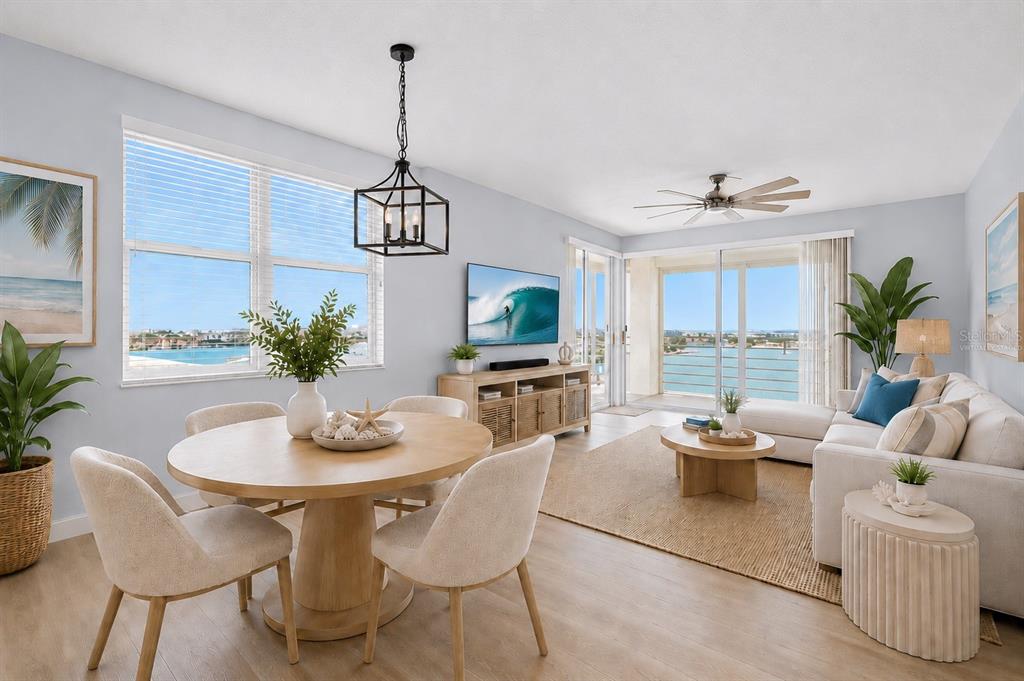 A bright living and dining area with light wood floors, coastal decor, and water views — 7963 SAILBOAT KEY BOULEVARD S UNIT PH801, SOUTH PASADENA, FL