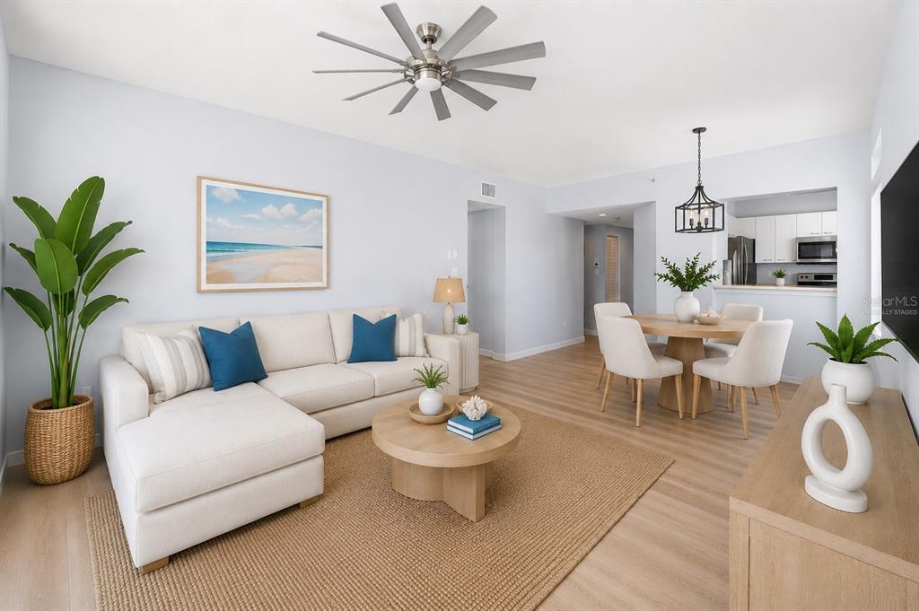 A bright living and dining area features light wood floors, a sectional sofa, and furniture — 7963 SAILBOAT KEY BOULEVARD S UNIT PH801, SOUTH PASADENA, FL