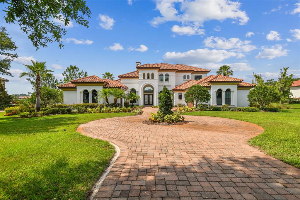 A large Mediterranean-style house with a tile roof and a circular brick paver driveway — 12310 STONELAKE RANCH BOULEVARD, THONOTOSASSA, FL