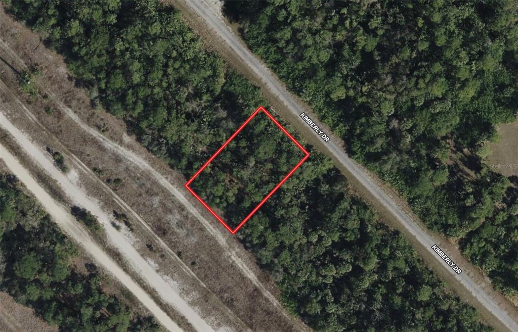 An aerial view shows a rectangular plot of land outlined in red near a road — KIMBERLY DRIVE, NORTH PORT, FL
