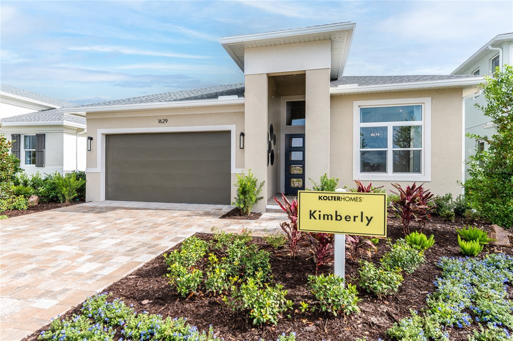 A covered patio features a wooden dining set, a bench, and a view of the yard — 1629 LAKE RESERVE DRIVE, DELAND, FL