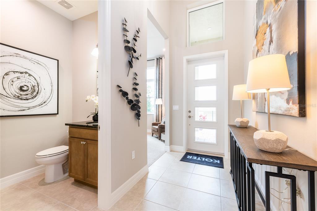 A home office features a wooden desk, a metal chandelier, tall windows, and a leather chair — 1629 LAKE RESERVE DRIVE, DELAND, FL